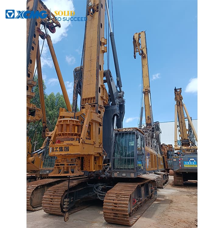 Used XCMG XR240E rotary drilling rig with mast lowered in a machinery yard